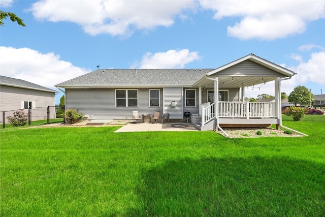 rear view of house featuring roof with shingles and a patio area