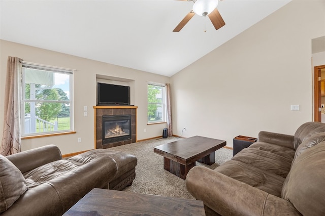 living room featuring a ceiling fan, a tile fireplace, carpet, baseboards, and high vaulted ceiling