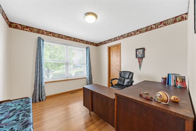home office with light wood-type flooring and baseboards