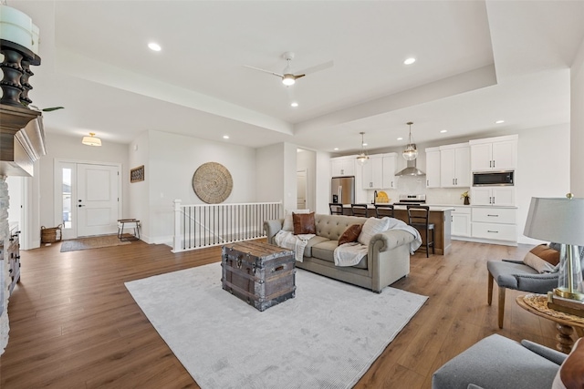 424 15th Ave SW, Mount Vernon, IA 52314 - living room featuring ceiling fan, recessed lighting, light wood finished floors, a raised ceiling, and baseboards