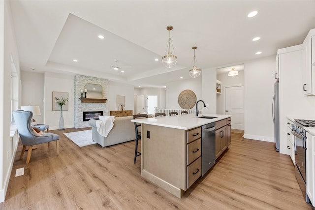 424 15th Ave SW, Mount Vernon, IA 52314 - kitchen with appliances with stainless steel finishes, a sink, a kitchen island with sink, light wood finished floors, and a breakfast bar area