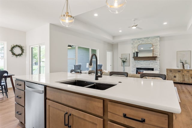 424 15th Ave SW, Mount Vernon, IA 52314 - kitchen featuring a sink, stainless steel dishwasher, a fireplace, open floor plan, and light wood-type flooring