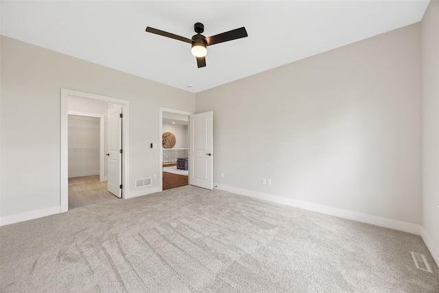 424 15th Ave SW, Mount Vernon, IA 52314 - unfurnished bedroom with carpet flooring, a spacious closet, baseboards, radiator heating unit, and a ceiling fan