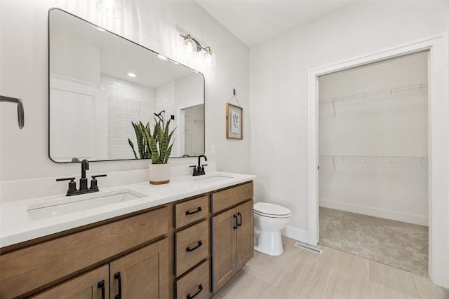 424 15th Ave SW, Mount Vernon, IA 52314 - full bathroom featuring toilet, a walk in closet, and double vanity