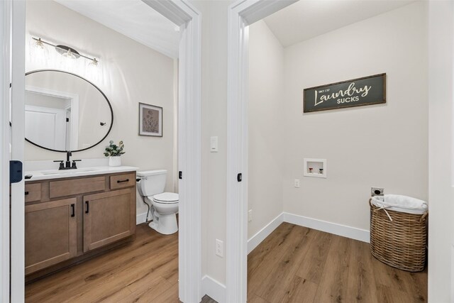 424 15th Ave SW, Mount Vernon, IA 52314 - bathroom featuring wood finished floors, toilet, vanity, and baseboards