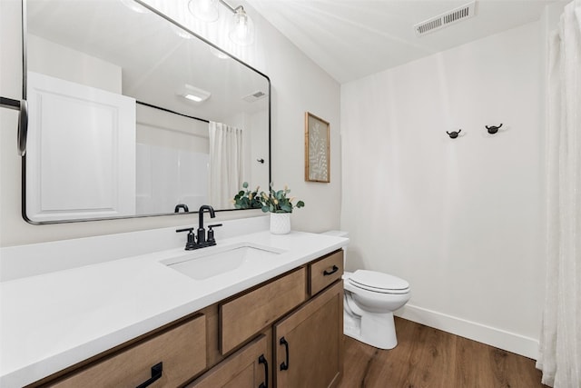 424 15th Ave SW, Mount Vernon, IA 52314 - bathroom featuring wood finished floors, toilet, vanity, baseboards, and curtained shower