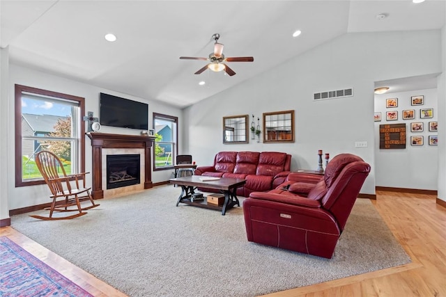395 Carlyle Dr, North Liberty, IA 52317 - living room with vaulted ceiling, healthy amount of natural light, baseboards, ceiling fan, and a tiled fireplace