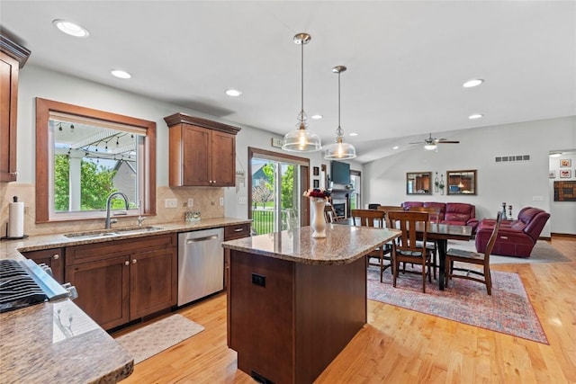 395 Carlyle Dr, North Liberty, IA 52317 - kitchen featuring dishwasher, a sink, light wood finished floors, open floor plan, and decorative backsplash