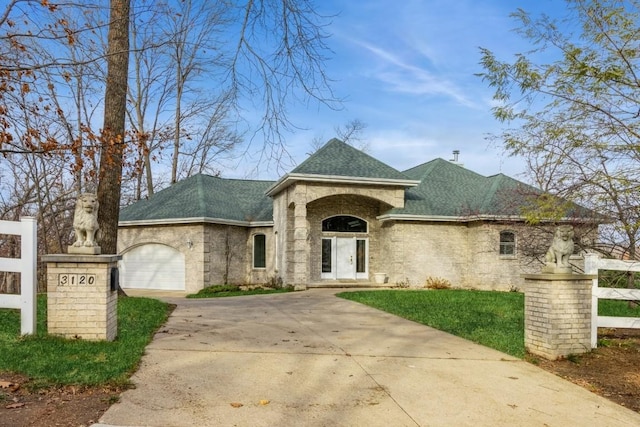 3120 Cottage Grove Ave SE, Cedar Rapids, IA 52403 - french country style house featuring a garage, concrete driveway, roof with shingles, and brick siding