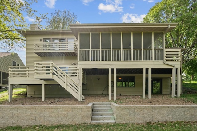 942 Evergreen Ct, Iowa City, IA 52245 - back of house with a chimney, stairway, a sunroom, and a deck