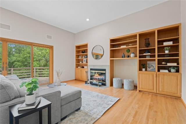 942 Evergreen Ct, Iowa City, IA 52245 - living room with light wood-style flooring, a tiled fireplace, and recessed lighting