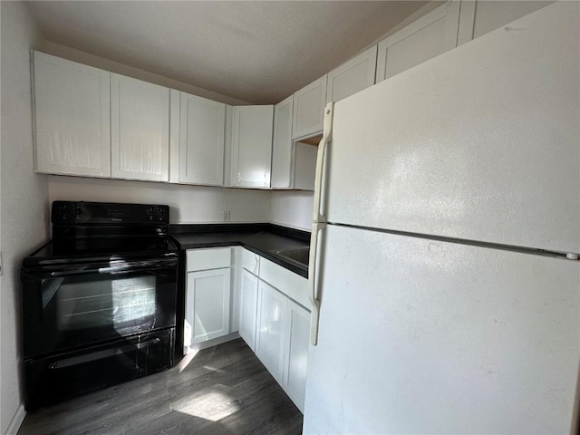 1338 22nd Ave SW, Cedar Rapids, IA 52404 - kitchen featuring freestanding refrigerator, black range with electric stovetop, dark wood-type flooring, dark countertops, and white cabinetry