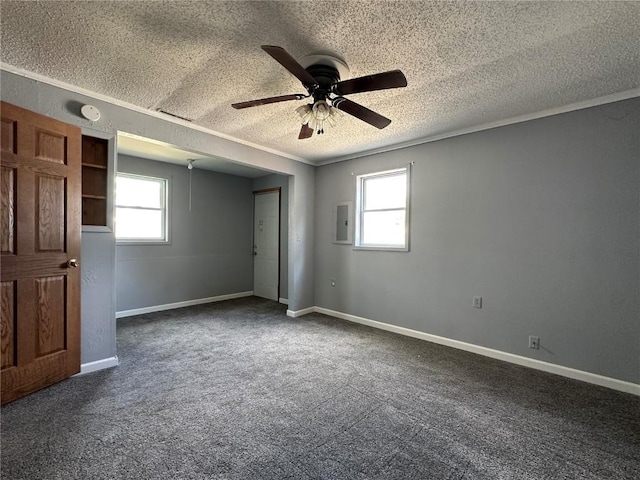 1338 22nd Ave SW, Cedar Rapids, IA 52404 - empty room featuring a textured ceiling, ceiling fan, dark carpet, electric panel, and baseboards
