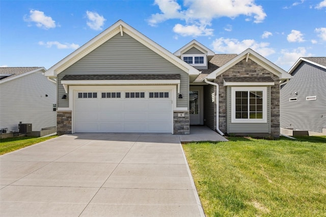 8 Pinnacle Ln, Tiffin, IA 52340 - craftsman-style house with stone siding, driveway, a front lawn, and an attached garage