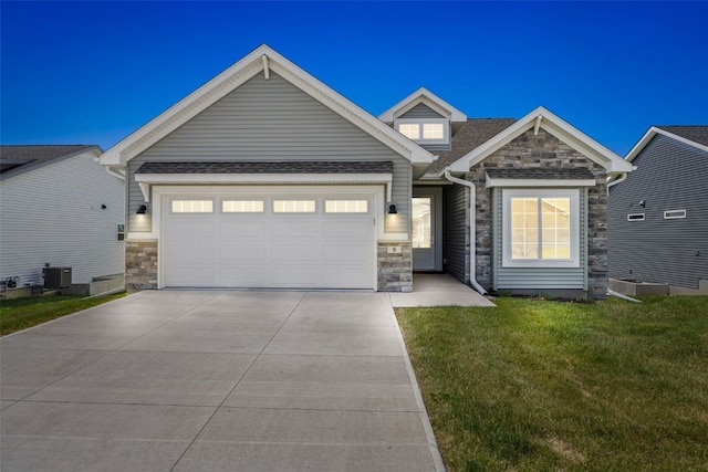 8 Pinnacle Ln, Tiffin, IA 52340 - view of front of house featuring stone siding, concrete driveway, an attached garage, and a front yard