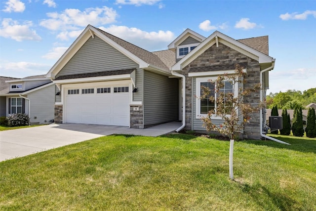 8 Pinnacle Ln, Tiffin, IA 52340 - view of front of house featuring stone siding, an attached garage, driveway, and a front yard
