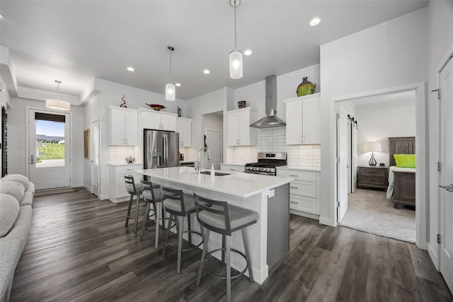 8 Pinnacle Ln, Tiffin, IA 52340 - kitchen featuring wall chimney range hood, stainless steel appliances, a sink, dark wood-style flooring, and decorative backsplash