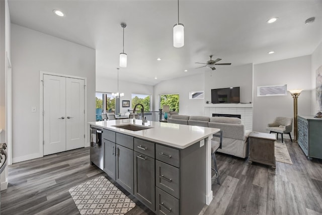 8 Pinnacle Ln, Tiffin, IA 52340 - kitchen featuring a sink, a ceiling fan, dark wood-type flooring, a brick fireplace, and stainless steel dishwasher
