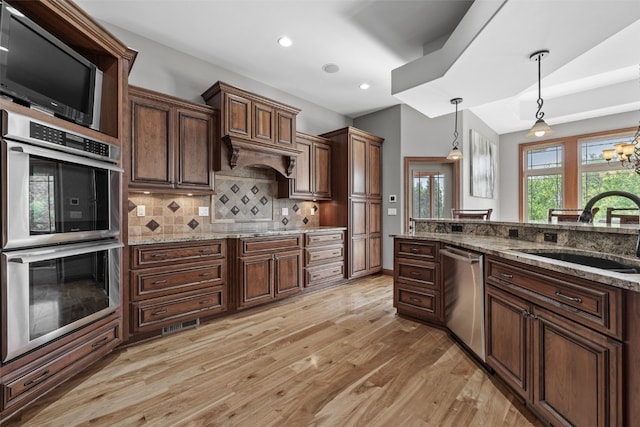 4355 Par Cir, Marion, IA 52302 - kitchen featuring stainless steel appliances, a sink, decorative light fixtures, light wood-type flooring, and decorative backsplash