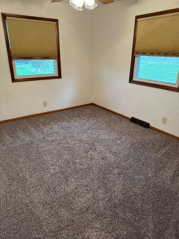 3105 Wilson Ave SW, Cedar Rapids, IA 52404 - spare room featuring baseboards, healthy amount of natural light, and carpet flooring