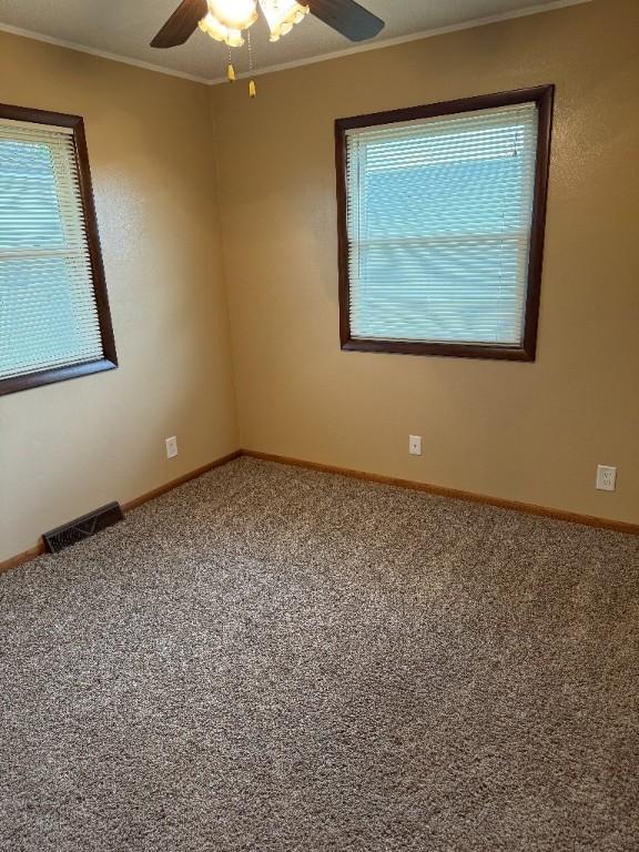 3105 Wilson Ave SW, Cedar Rapids, IA 52404 - carpeted empty room with crown molding, a ceiling fan, and baseboards