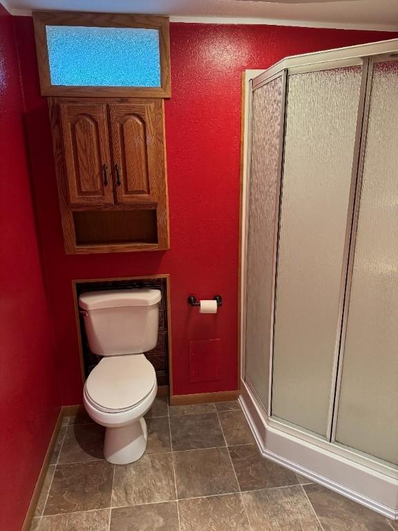 3105 Wilson Ave SW, Cedar Rapids, IA 52404 - full bathroom featuring baseboards, a stall shower, and toilet