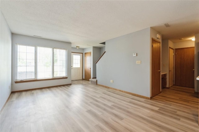 3035 English Glen Ct Unit D7, Marion, IA 52302 - empty room with light wood finished floors, baseboards, and a textured ceiling