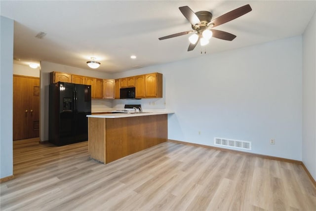 3035 English Glen Ct Unit D7, Marion, IA 52302 - kitchen with black appliances, a peninsula, light countertops, light wood-type flooring, and baseboards