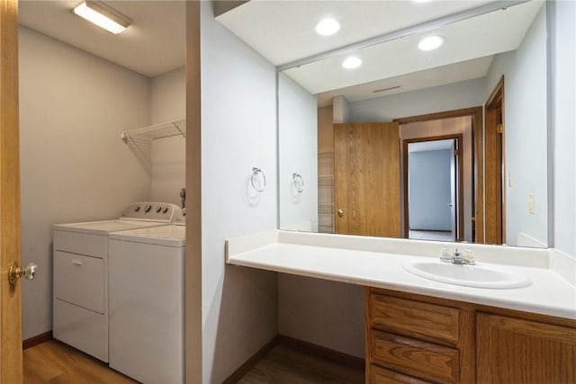 3035 English Glen Ct Unit D7, Marion, IA 52302 - bathroom with washing machine and dryer, vanity, wood finished floors, recessed lighting, and baseboards