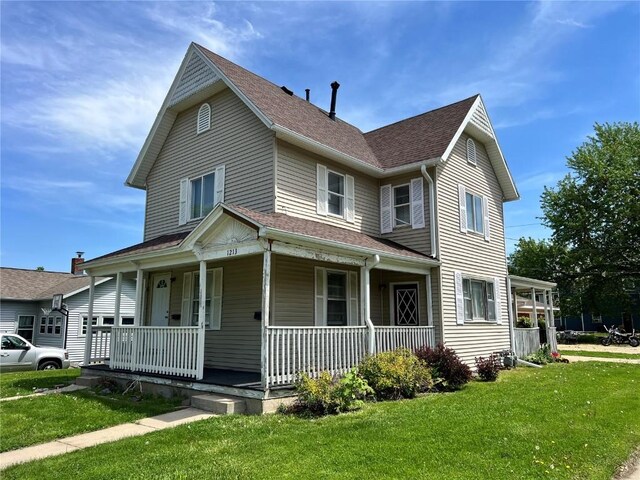 1213 11th St, Marion, IA 52302 - view of front of house featuring covered porch, a front yard, and a shingled roof