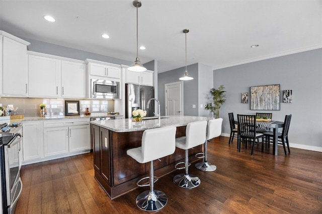 901 E 2nd Ave Unit 5, Coralville, IA 52241 - kitchen featuring stainless steel appliances, dark wood finished floors, a sink, tasteful backsplash, and light stone countertops