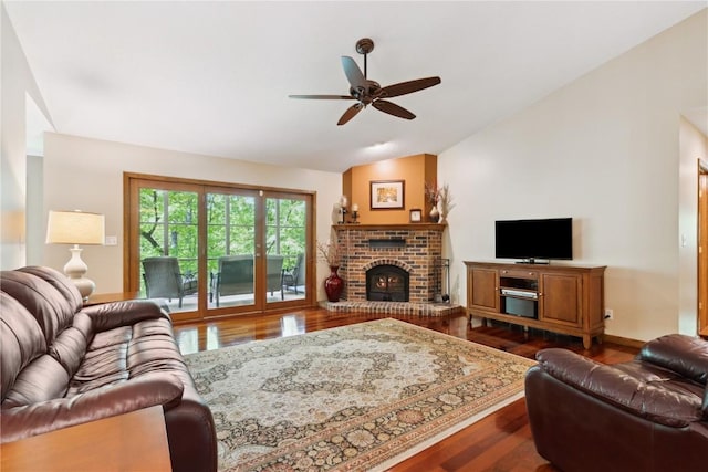 1445 NE Butternut Ln, Swisher, IA 52338 - living room with lofted ceiling, dark wood-style floors, a ceiling fan, a fireplace, and baseboards
