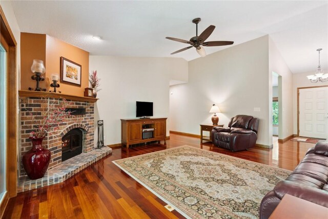 1445 NE Butternut Ln, Swisher, IA 52338 - living room featuring lofted ceiling, dark wood-style floors, a brick fireplace, ceiling fan, and a chandelier