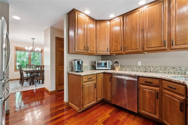 1445 NE Butternut Ln, Swisher, IA 52338 - kitchen with stainless steel appliances, dark wood-type flooring, a chandelier, brown cabinets, and recessed lighting