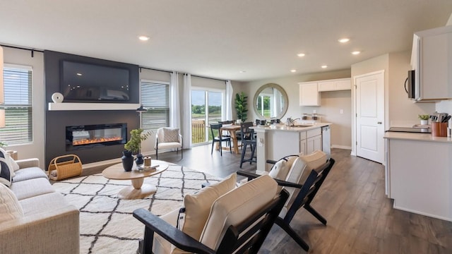 626 Maddie Ln, Tiffin, IA 52340 - living room featuring recessed lighting, a glass covered fireplace, dark wood finished floors, and baseboards