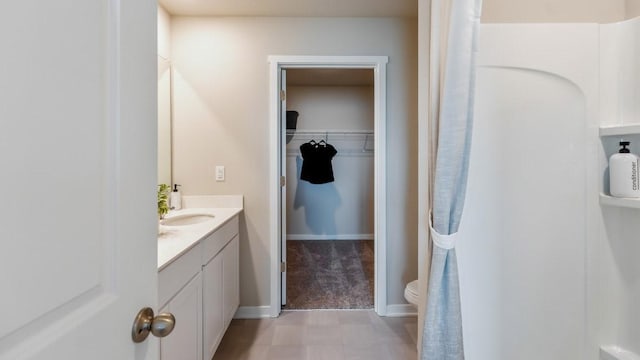 626 Maddie Ln, Tiffin, IA 52340 - full bathroom featuring vanity, toilet, a spacious closet, and baseboards
