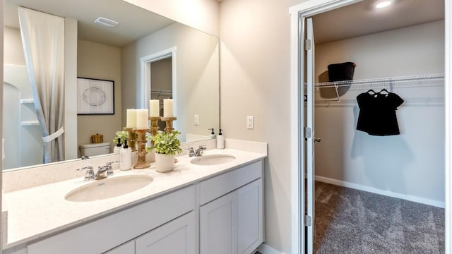 626 Maddie Ln, Tiffin, IA 52340 - full bath featuring toilet, a walk in closet, double vanity, and baseboards