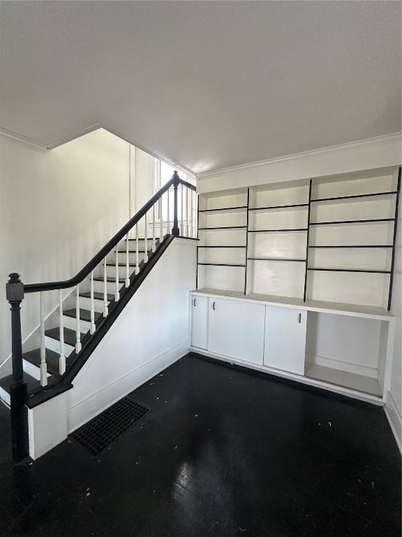 800 19th St SE, Cedar Rapids, IA 52403 - unfurnished living room with stairway, baseboards, and crown molding