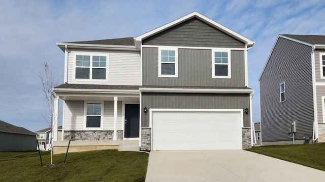 700 Maddie Ln, Tiffin, IA 52340 - craftsman-style home featuring covered porch, stone siding, concrete driveway, a front lawn, and an attached garage