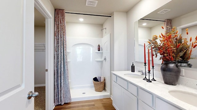 700 Maddie Ln, Tiffin, IA 52340 - bathroom with a stall shower, double vanity, wood finished floors, and recessed lighting