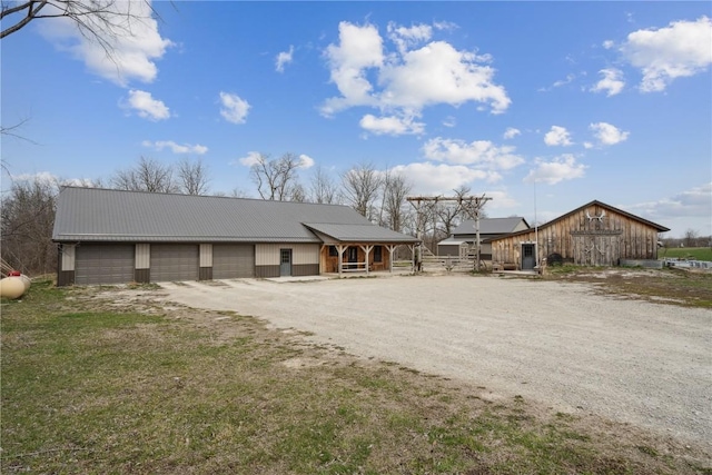 2527 61st St Ln Lot 1, Vinton, IA 52349 - view of front of house featuring a barn, metal roof, dirt driveway, an outdoor structure, and covered porch