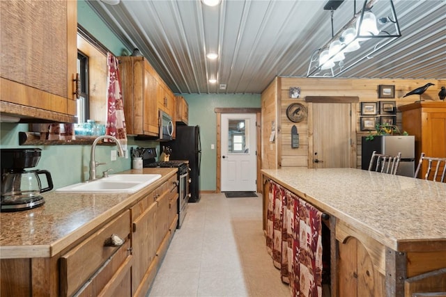 2527 61st St Ln Lot 1, Vinton, IA 52349 - kitchen featuring a sink, appliances with stainless steel finishes, a kitchen island, brown cabinets, and light countertops