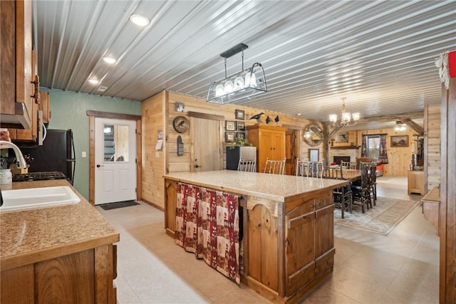 2527 61st St Ln Lot 1, Vinton, IA 52349 - kitchen with a chandelier, light countertops, a sink, wood walls, and a peninsula