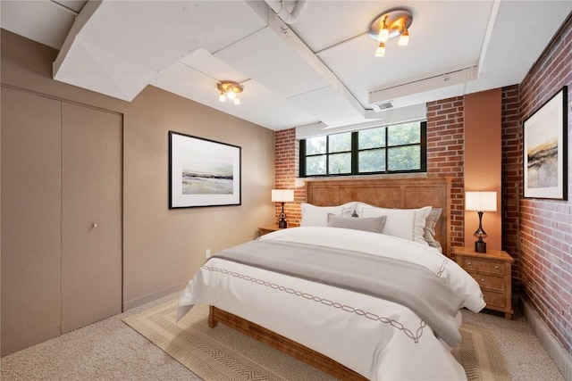 905 3rd St SE Unit 111, Cedar Rapids, IA 52401 - bedroom featuring brick wall, light carpet, a closet, and baseboards