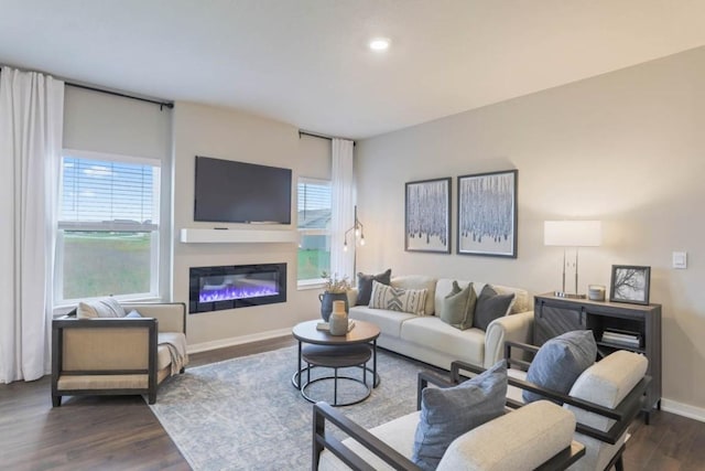 704 Magnolia Way, Tiffin, IA 52340 - living room featuring dark wood-style floors, baseboards, a glass covered fireplace, and recessed lighting