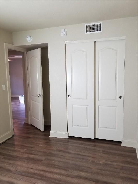 200 Grandview Ct Unit 204, Iowa City, IA 52246 - unfurnished bedroom featuring baseboards, dark wood-style flooring, and a closet