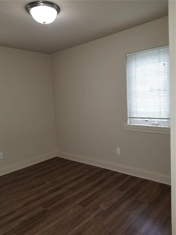 200 Grandview Ct Unit 204, Iowa City, IA 52246 - spare room with baseboards and dark wood-type flooring