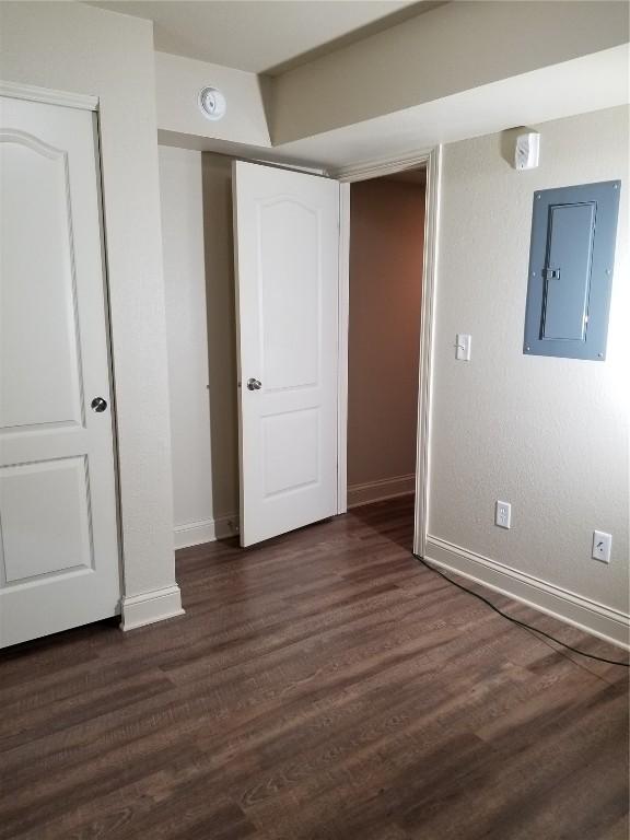 200 Grandview Ct Unit 204, Iowa City, IA 52246 - unfurnished bedroom with electric panel, baseboards, dark wood-style floors, and a closet