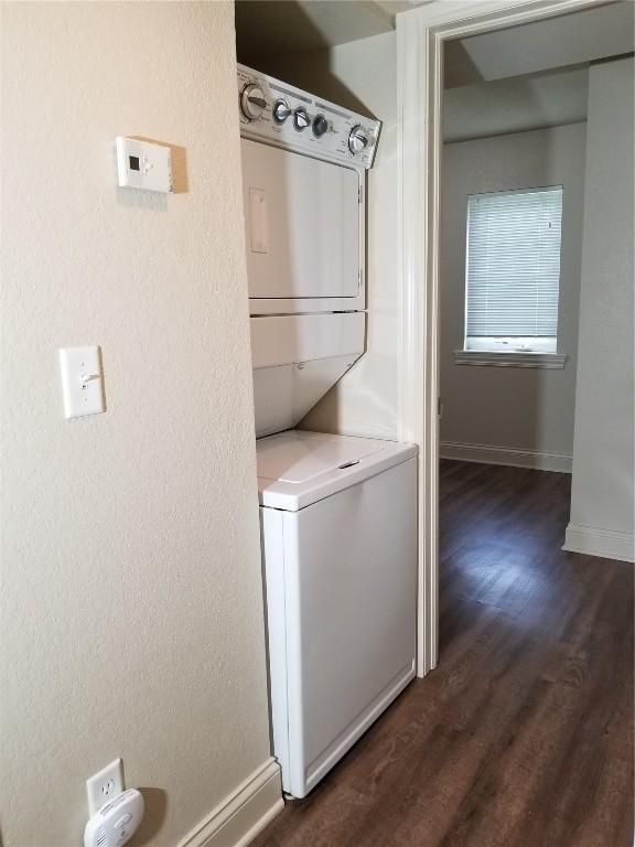 200 Grandview Ct Unit 204, Iowa City, IA 52246 - laundry area with estacked washer and dryer, dark wood-style floors, and baseboards