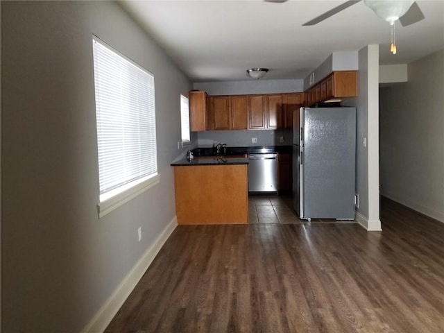 200 Grandview Ct Unit 204, Iowa City, IA 52246 - kitchen featuring stainless steel appliances, dark countertops, dark wood finished floors, baseboards, and brown cabinetry